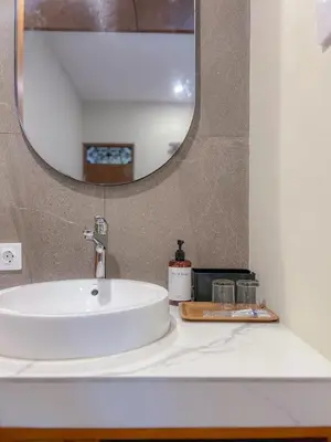 a bathroom sink with a mirror on a counter at Kaman Bali Guesthouse in Seminyak