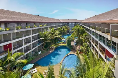 an aerial view of a hotel with a pool and palm trees at Ramada Encore by Wyndham Seminyak Bali in Seminyak