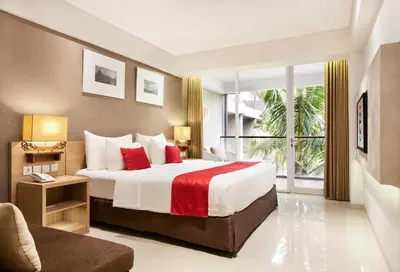 a bedroom with a large bed and a large window at Ramada Encore by Wyndham Seminyak Bali in Seminyak