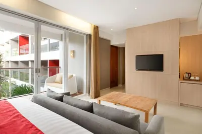 a living room with a couch and a tv at Ramada Encore by Wyndham Seminyak Bali in Seminyak