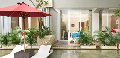 a lobby with a red umbrella and potted plants at Ramada Encore by Wyndham Seminyak Bali in Seminyak