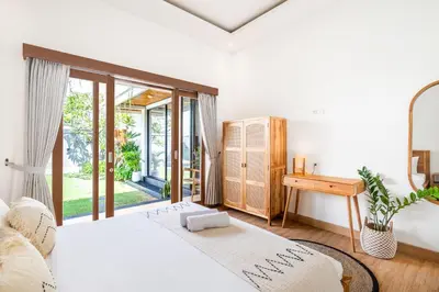 a bedroom with a bed and a desk and a window at Ami villa in the heart of Canggu in Canggu