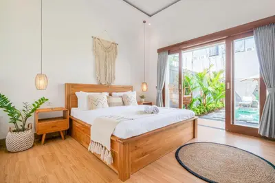 a bedroom with a bed and a large window at Ami villa in the heart of Canggu in Canggu