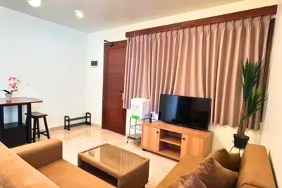 a living room with a couch and a flat screen tv at Narendra 1 BR Apartment in Jimbaran