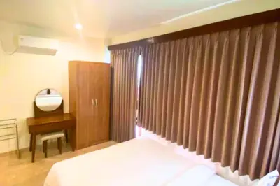 a bedroom with a bed and a dresser and a mirror at Narendra 1 BR Apartment in Jimbaran