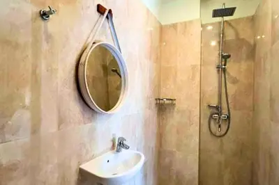 a bathroom with a sink and a mirror and a shower at Narendra 1 BR Apartment in Jimbaran