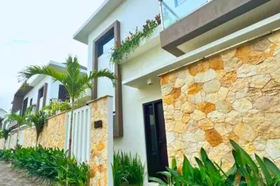 a house with a stone wall and a door at Narendra 1 BR Apartment in Jimbaran