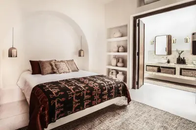 a white bedroom with a bed and a bathroom at Villa Almaz Seminyak in Seminyak