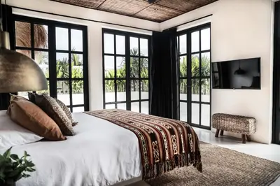 a bedroom with a bed and large windows at Villa Almaz Seminyak in Seminyak