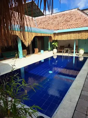 a swimming pool in front of a villa at Lavender star house in Kuta