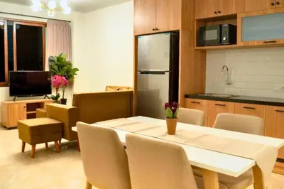 a kitchen and dining room with a table and chairs at Adaline 2 BR Apartment in Jimbaran