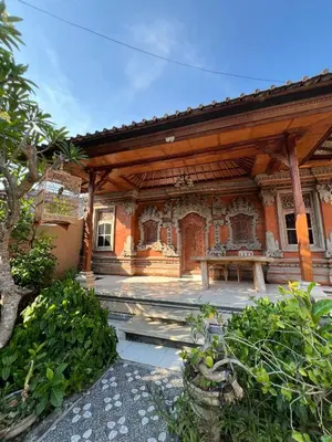 a house with a pavilion with a table in front of it at Pondok Ledog 02 in Jimbaran
