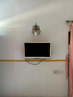 a flat screen tv hanging on a wall at Pondok Ledog 02 in Jimbaran