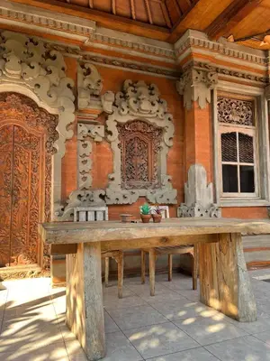 a large wooden table in front of a building at Pondok Ledog 02 in Jimbaran