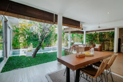 a living room with a wooden table and chairs at Cozy & Private 1 Bed Pool Villa in Trendy Umalas in Kerobokan