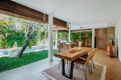 an open living room with a wooden table and chairs at Cozy & Private 1 Bed Pool Villa in Trendy Umalas in Kerobokan