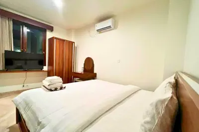 a bedroom with a bed and a tv and a window at Lariska 1 BR Superior Queen Room in Jimbaran