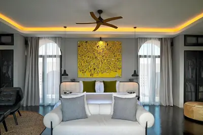 a living room with a white couch and a ceiling fan at CARPEDIEM VILLA BALI operated by Villa Nila in Canggu