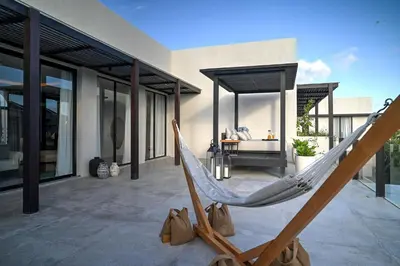 a hammock on the patio of a house at CARPEDIEM VILLA BALI operated by Villa Nila in Canggu