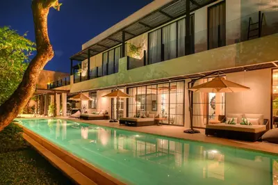 a house with a swimming pool in front of a building at CARPEDIEM VILLA BALI operated by Villa Nila in Canggu