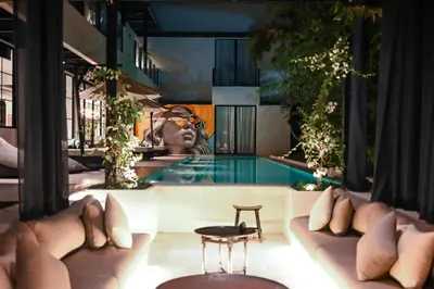 a pool at a hotel with a painting on the wall at CARPEDIEM VILLA BALI operated by Villa Nila in Canggu
