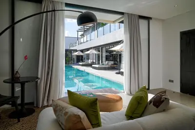 a living room with a couch and a swimming pool at CARPEDIEM VILLA BALI operated by Villa Nila in Canggu