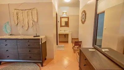 a bedroom with a dresser and a mirror at Leluhur 2 - 3BR, Free Nmax, Airport Pick Up and YT Premium in Seminyak