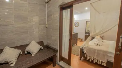 a bedroom with a bed and a mirror and a bench at Leluhur 2 - 3BR, Free Nmax, Airport Pick Up and YT Premium in Seminyak