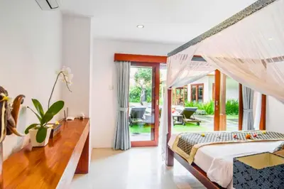 a bedroom with a canopy bed and a patio at Minara 4 BR Private Pool Villa in Canggu