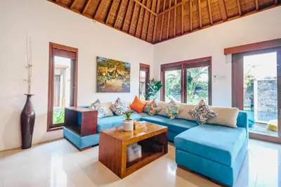 a living room with a blue couch and a table at Minara 4 BR Private Pool Villa in Canggu