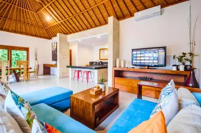 a living room with a blue couch and a table at Minara 4 BR Private Pool Villa in Canggu