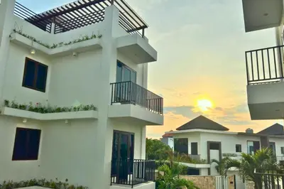 a white building with a sunset in the background at Reline 1 BR Studio with Sofa Bed in Jimbaran