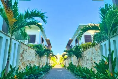 a street between two buildings with palm trees at Reline 1 BR Studio with Sofa Bed in Jimbaran
