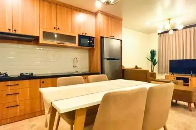 a kitchen with a table and chairs and a refrigerator at Anyaa 3 BR Apartment in Jimbaran