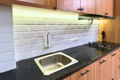 a kitchen counter with a sink and a stove at Anyaa 3 BR Apartment in Jimbaran
