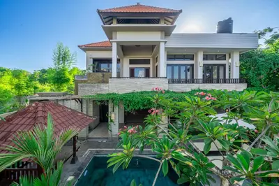 a house with a swimming pool in front of it at Aradhia Villa Nusa Dua in Nusa Dua