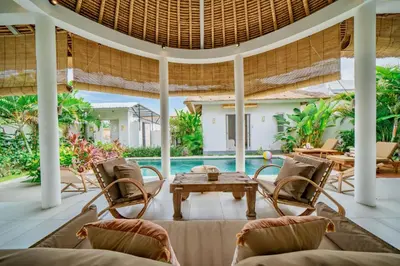 an outdoor patio with a table and chairs and a pool at Villa Antea in Seminyak
