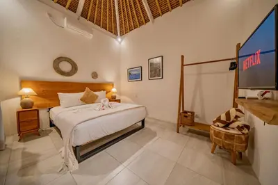 a bedroom with a bed and a flat screen tv at Villa Antea in Seminyak