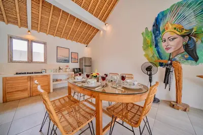 a dining room with a table and a painting on the wall at Villa Antea in Seminyak