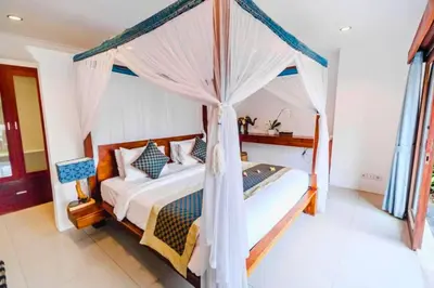 a bedroom with a bed with a canopy at Camana 1 BR Villa With Shared Pool in Canggu