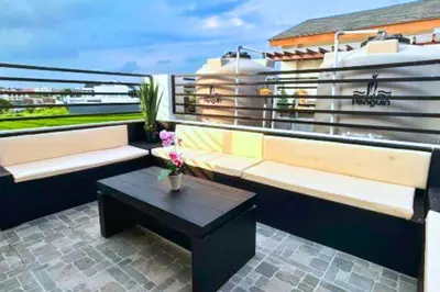 a balcony with a bench and a coffee table at Willy 4 BR Comfort Quadruple Room in Jimbaran