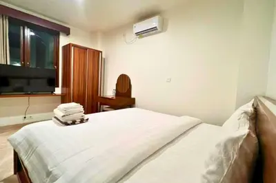 a bedroom with a bed and a tv and a window at Willy 4 BR Comfort Quadruple Room in Jimbaran