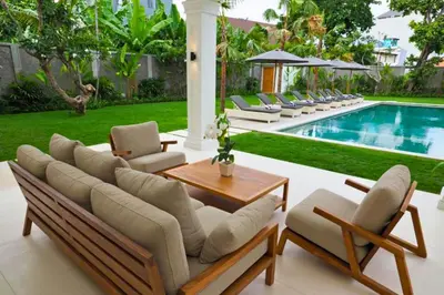 a patio with lounge chairs and a swimming pool at Narasnama 6 BR Private Pool Villa in Canggu