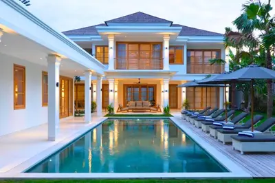 a villa with a swimming pool in front of a house at Narasnama 6 BR Private Pool Villa in Canggu