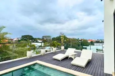 a patio with white chairs and a swimming pool at Abimana 5 BR Presidential Suite Private Pool in Jimbaran