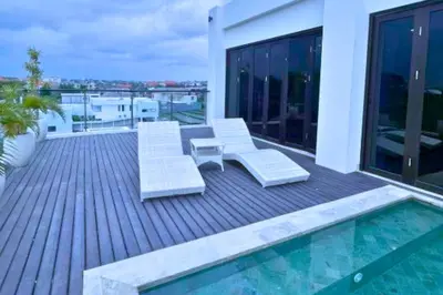 a deck with two chairs and a pool on a building at Abimana 5 BR Presidential Suite Private Pool in Jimbaran