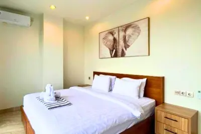 a bedroom with a large bed with white sheets at Abimana 5 BR Presidential Suite Private Pool in Jimbaran
