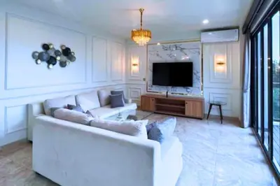 a living room with a white couch and a television at Abimana 5 BR Presidential Suite Private Pool in Jimbaran
