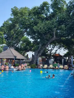 a group of people swimming in a swimming pool at C&C Jayakarta Residence Apartment Legian Kuta Bali in Seminyak