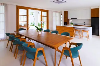 a dining room with a wooden table and chairs at Nawasena 5 BR Private Pool Villa in Canggu
